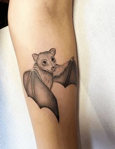 a small bat tattoo on the right arm and leg, it is black and white