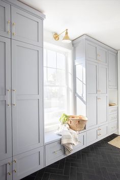 a large kitchen with white cabinets and black tile flooring, along with a window seat