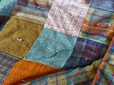 a patchwork blanket with pins sticking out of it