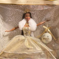 a barbie doll in a gold and white dress with a tiara on her head