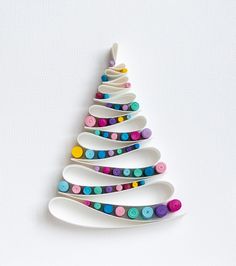 a christmas tree made out of spoons on a white surface with buttons in the shape of an xmas tree