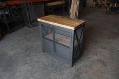 a kitchen island made out of metal and wood in a garage with lots of tools