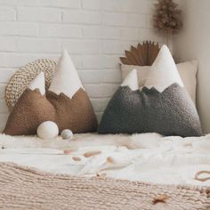 two decorative pillows sitting on top of a bed