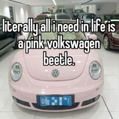 a pink vw beetle parked in a showroom with the words literally all i need in life is a pink volkswagen beetle