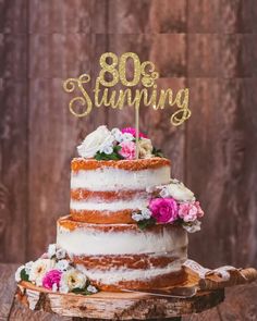 a three tiered cake with flowers and the words 80 strumming on top