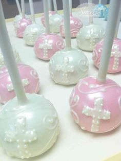 pink and white cake pops with cross on them