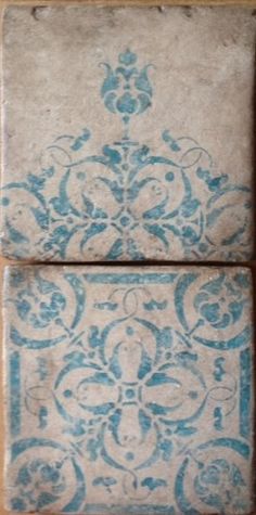 two blue and white tiles sitting on top of each other