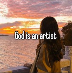 a woman looking out at the ocean with text that reads, god is an artist