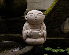 a small statue sitting on top of a fountain