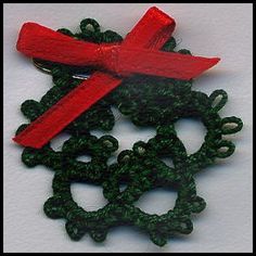 three pieces of red and green broochies on a white surface with black beads