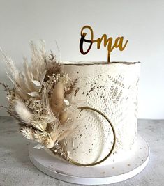 a white cake with gold letters and feathers on top