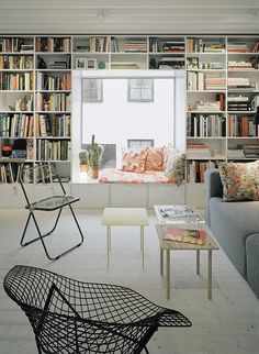 a living room filled with lots of bookshelves next to a couch and coffee table