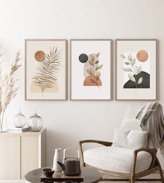 three framed art prints hanging on the wall above a chair and coffee table in a living room