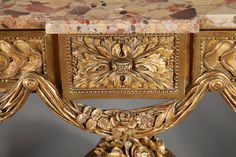 an ornately decorated gold table with marble top