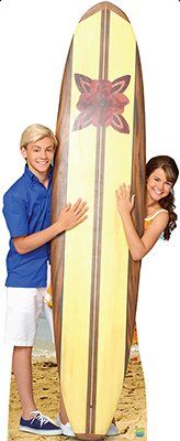 two people standing next to each other holding a surfboard in front of the camera