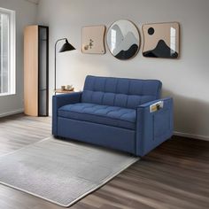 a blue couch sitting on top of a hard wood floor next to a white rug