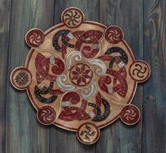 an intricately designed wooden plate on a wood floor with the word's and symbols written in cursive writing