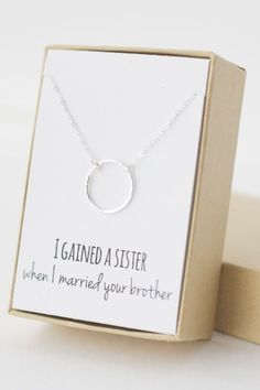 a small silver necklace in a box with the message i gaind aster when i married your brother