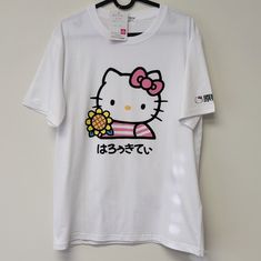 Sanrio Hello Kitty Hk Sunflower Tshirt Top New With Tag Size Large Color White Pink Yellow Black And Green Front Print Features Hello Kitty Holding A Sunflower Wearing A Pink Stripe Shirt Hello Kitty Is Also Printed On The Sleeve Crewneck Short Sleeve Imported From Japan Approximate Measurements Flat Lay Pit To Pit 20 1/2" Shoulder To Hem 26 1/2" New To Poshmark? Use Offer Code Ken_ken1 When You Sign Up For $10 Off Your First Purchase. Smoke Free Home 347 Kawaii White T-shirt For Summer, Kawaii Hello Kitty Cotton T-shirt, Hello Kitty Kawaii T-shirt For Spring, Kawaii Hello Kitty T-shirt For Spring, Cute Hello Kitty Cotton T-shirt, Cute Cotton Hello Kitty T-shirt, Spring Kawaii Hello Kitty T-shirt, White Hello Kitty Cotton T-shirt, White Hello Kitty Print Fun T-shirt