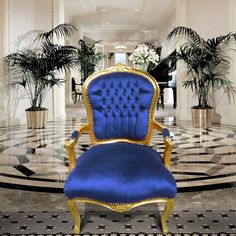 a blue and gold chair sitting in the middle of a room