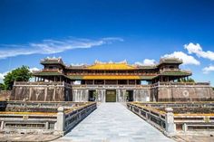 the entrance to an old chinese building with yellow roof and gold trimmings on it