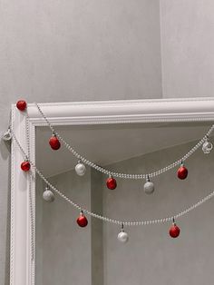 a mirror with christmas ornaments hanging from it