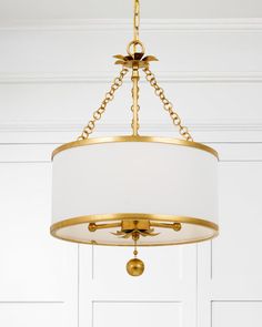 a chandelier hanging from the ceiling in a room with white paneled walls