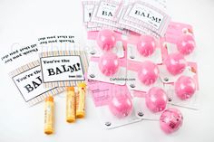 some pink balls are sitting next to each other on a white surface with tags and markers