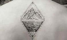 the back of a man's neck with mountains and water in it, on top of