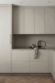 a kitchen with white cabinets and wood floors