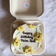 a birthday cake in a box on a bed