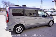 the back end of a silver van parked in a parking lot