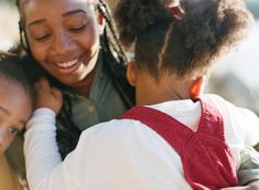 a woman and two children hugging each other