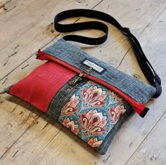 the purse is made out of old jeans and has a red lining on the side