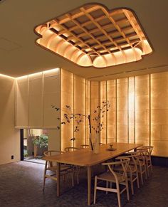 a dining room table with chairs and lights on the ceiling above it is lit by dim lighting