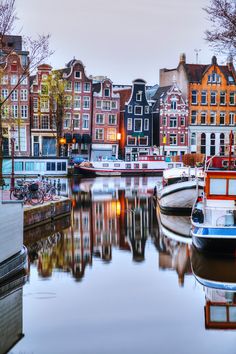 several boats are docked in the water near some buildings