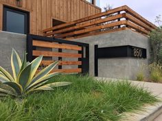 a house with wooden slats on the side and grass growing in front of it