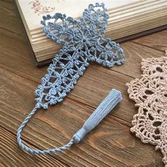 two crocheted doily are sitting on a table next to an open book