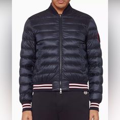 Moncler's Luxury Robert Bomber Is The Optimum Choice For Cooler Weather Season And Will Ensure Warmth And Comfort. The Rib-Knit Baseball Collar Lends A Sport-Luxe Aesthetic Coupled With The Tri-Colour Ribber Trims Brand's Signature Logo Patch Features On The Sleeve Padded With Luxurious Down Ensuring This Staple Is Perfect For Colder Temperatures Luxury Navy Long Sleeve Outerwear, Designer Navy Long Sleeve Outerwear, Fitted Blue Outerwear With Ribbed Cuffs, Designer Blue Outerwear With Padded Collar, Luxe Aesthetic, Sport Luxe, Tri Colour, Weather Seasons, Moncler Jacket