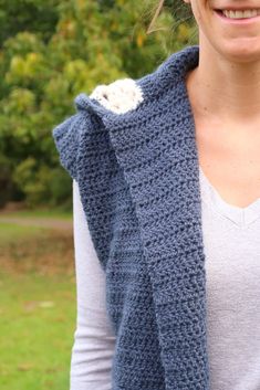 a woman wearing a blue crocheted vest and smiling