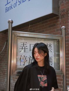 a woman standing in front of a bank of stars sign with her hand on her hip