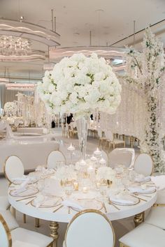 a table set with white flowers and candles for a wedding reception at the ritz