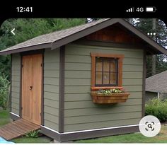 a small shed with a window and flower box