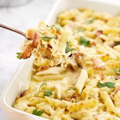 a spoon full of macaroni and cheese casserole with meat on top