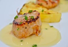 some kind of food that is on a white plate with yellow sauce and garnishes