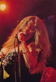 a woman singing into a microphone on stage