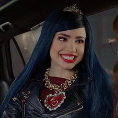 a woman with blue hair wearing a black leather jacket and red lipstick in a car