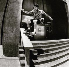 a man riding a skateboard down the side of a flight of stairs