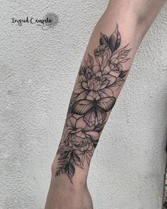 a black and white flower tattoo on the arm