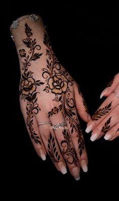 two hands with henna tattoos on them